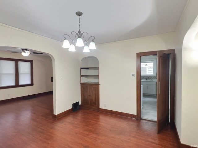 unfurnished dining area with arched walkways, dark wood-type flooring, and baseboards