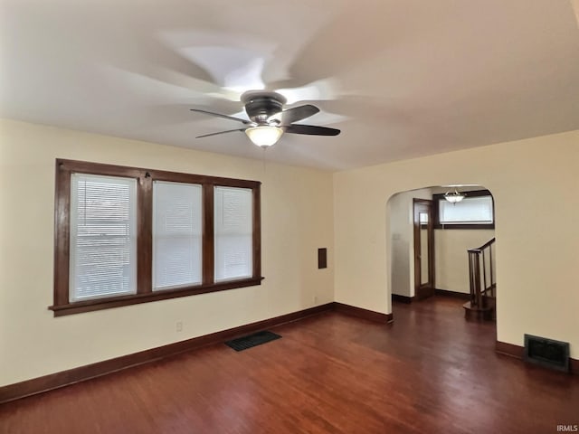 unfurnished room featuring baseboards, arched walkways, visible vents, and ceiling fan