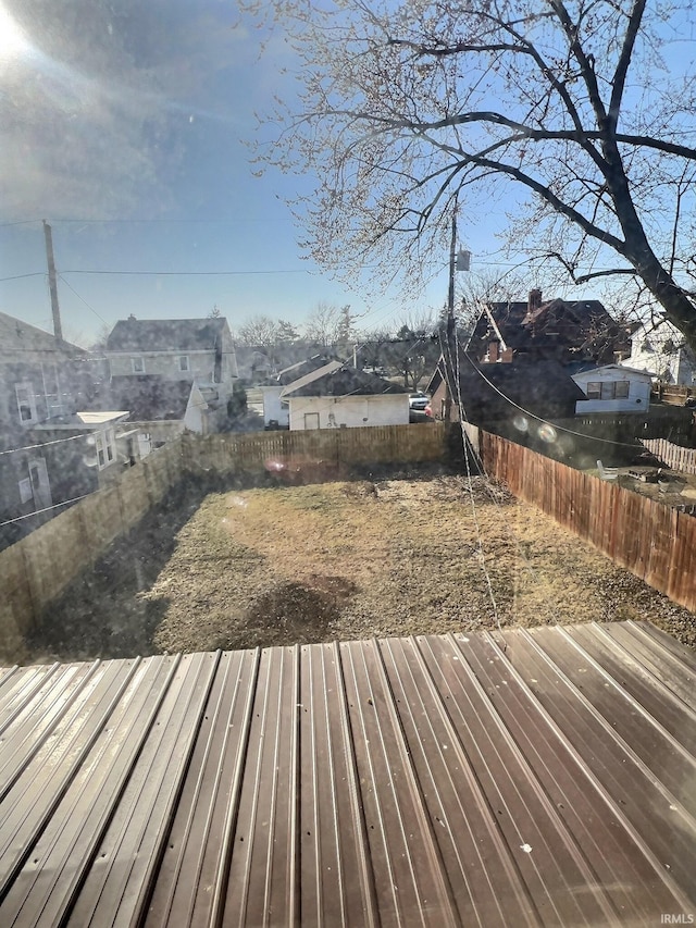 wooden terrace with a fenced backyard