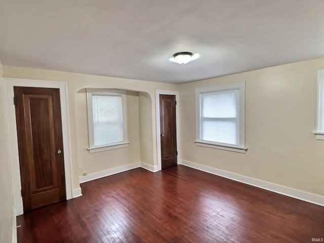 empty room with wood finished floors and baseboards