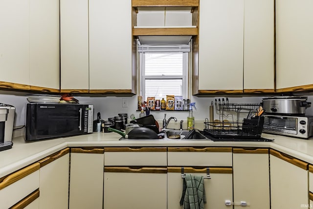 kitchen featuring a toaster, white cabinets, and light countertops