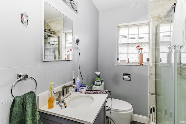 bathroom featuring vanity, tile walls, toilet, and a stall shower