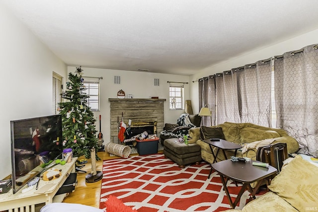 living room with a fireplace, wood finished floors, and visible vents