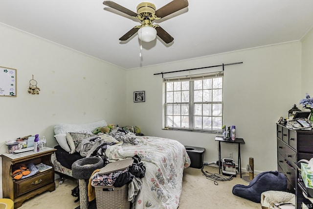 bedroom with crown molding, a ceiling fan, and light carpet