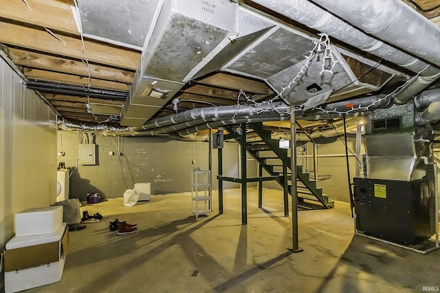 unfinished basement with heating unit, washer / dryer, electric panel, and visible vents