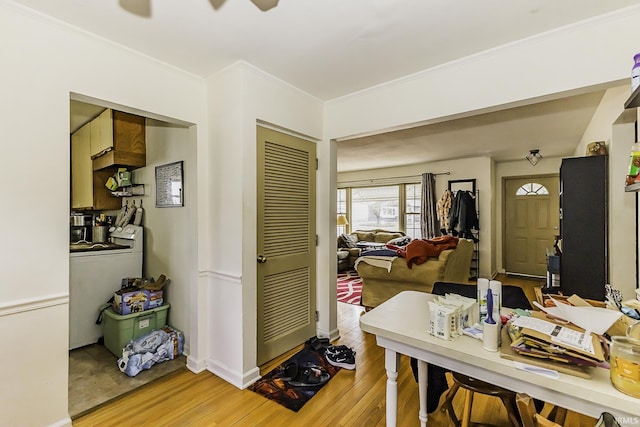 dining area featuring light wood-type flooring, baseboards, and ornamental molding