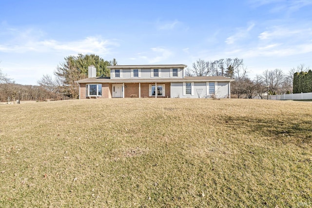 traditional-style home featuring a front lawn, fence, and a chimney