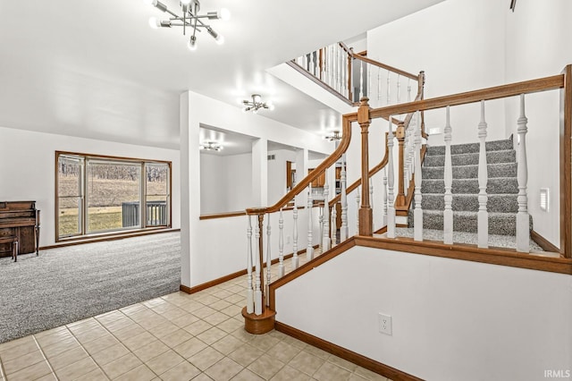 stairs featuring tile patterned floors, a notable chandelier, baseboards, and carpet floors