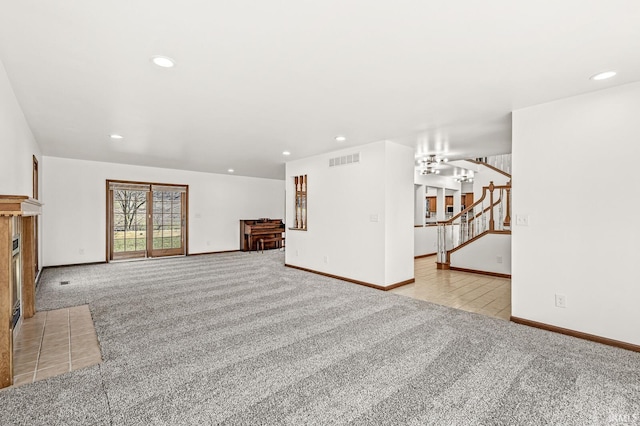 unfurnished living room featuring stairs, recessed lighting, light colored carpet, and visible vents