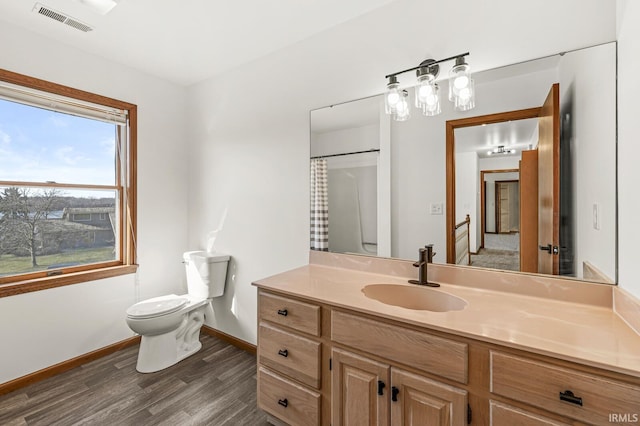 bathroom with visible vents, toilet, wood finished floors, baseboards, and vanity