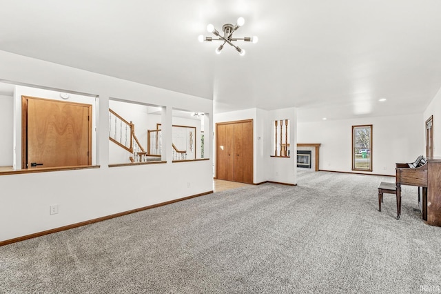 living room featuring stairs, an inviting chandelier, baseboards, and light carpet