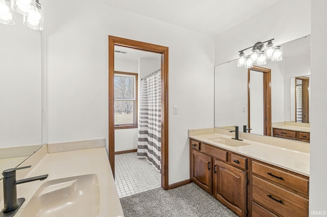 full bath featuring vanity and baseboards