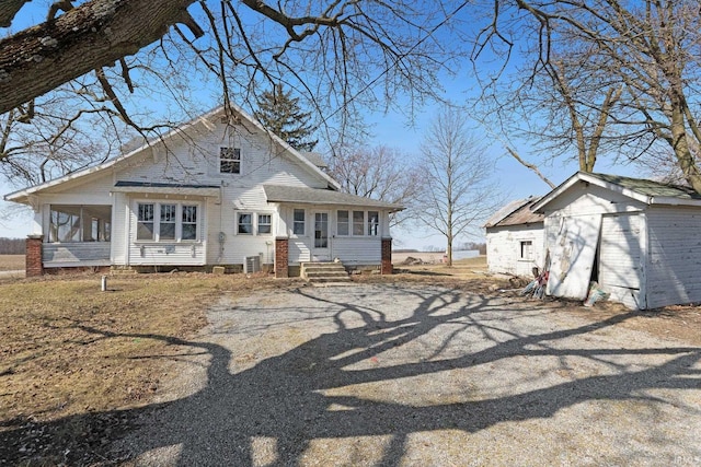 view of front of property with an outdoor structure and a sunroom