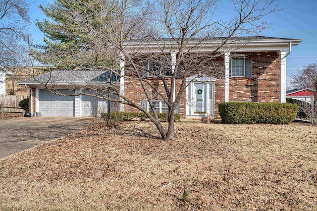 raised ranch with a garage, brick siding, and aphalt driveway