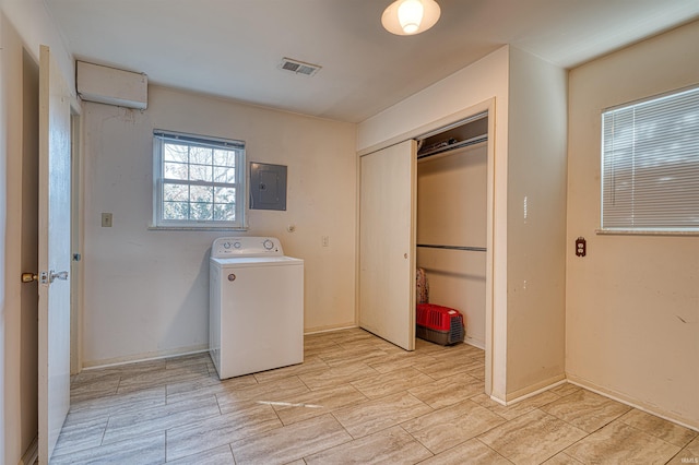 clothes washing area with visible vents, baseboards, electric panel, laundry area, and washer / dryer