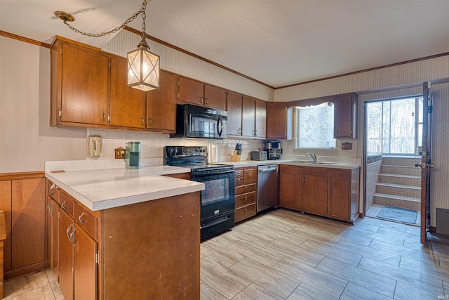 kitchen featuring black appliances, light countertops, a wainscoted wall, and brown cabinets