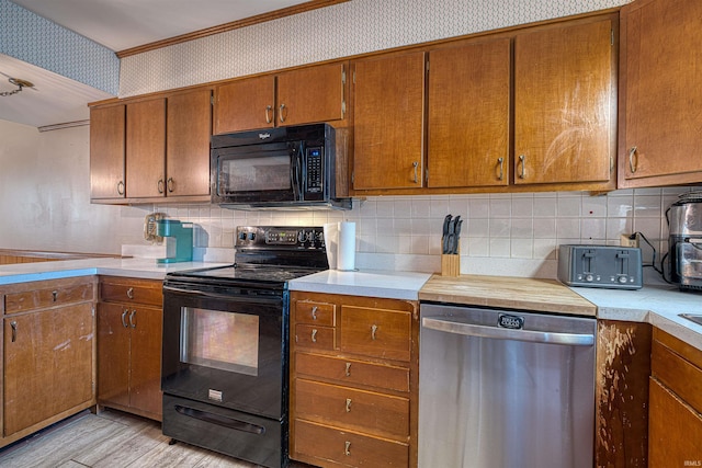 kitchen with wallpapered walls, black appliances, brown cabinetry, and light countertops