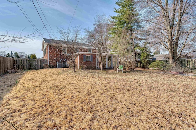 back of property featuring a fenced backyard and brick siding