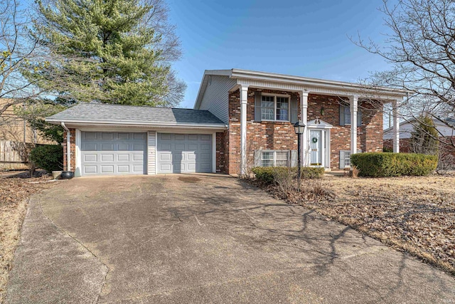 view of front of home with a garage, brick siding, and driveway