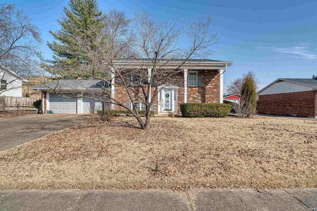 view of front of home featuring a garage, fence, brick siding, and driveway