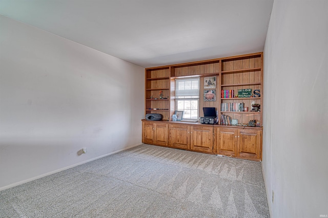 unfurnished office featuring light colored carpet and baseboards