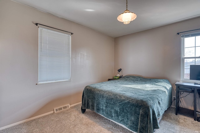 carpeted bedroom featuring baseboards and visible vents