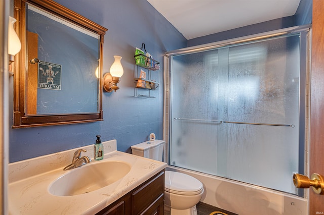 full bathroom featuring vanity, toilet, and shower / bath combination with glass door