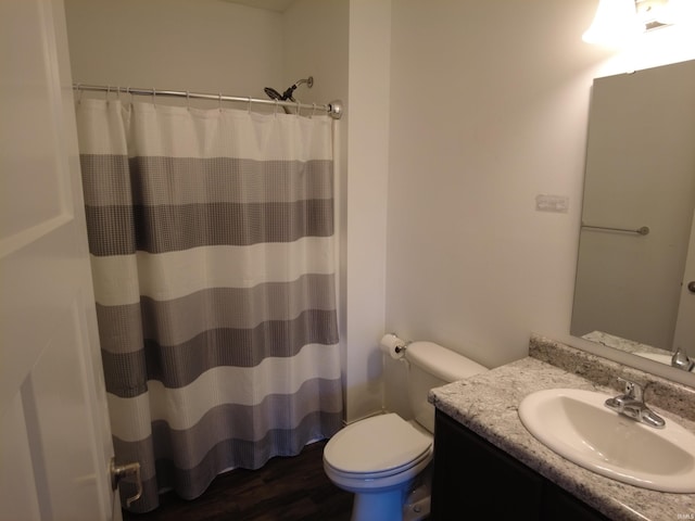 full bathroom featuring vanity, a shower with shower curtain, toilet, and wood finished floors