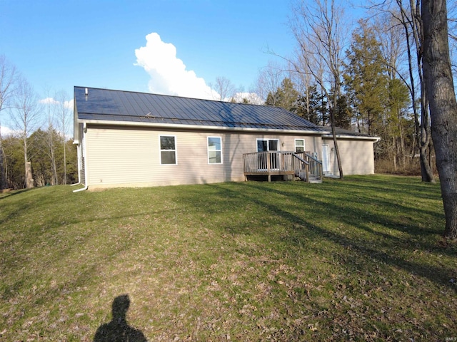 back of property featuring a deck, a yard, a standing seam roof, and metal roof