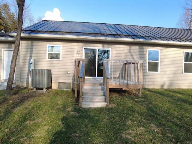 rear view of house featuring a wooden deck, central AC unit, metal roof, a yard, and a standing seam roof