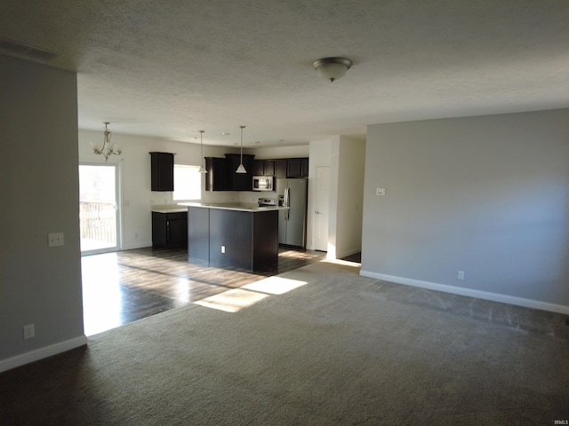 unfurnished living room featuring an inviting chandelier, baseboards, carpet floors, and a textured ceiling