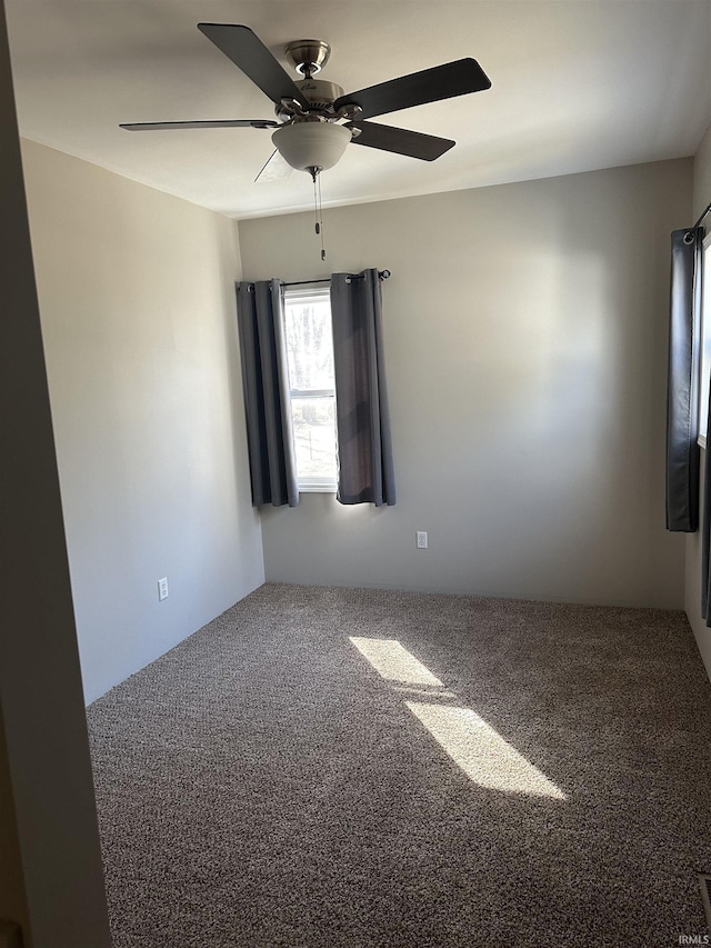 carpeted empty room featuring a ceiling fan