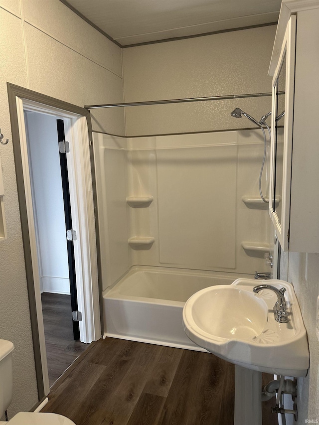 full bathroom featuring shower / tub combination, toilet, and wood finished floors