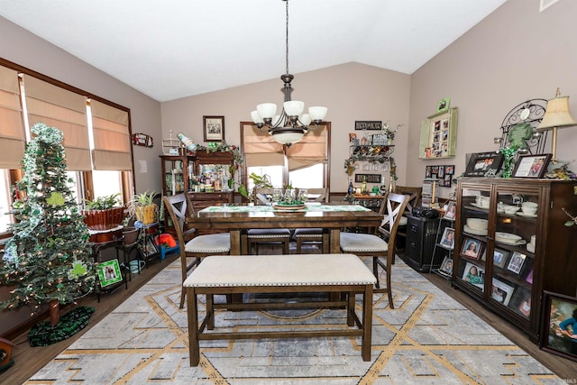 dining room featuring light wood-style floors, an inviting chandelier, and vaulted ceiling