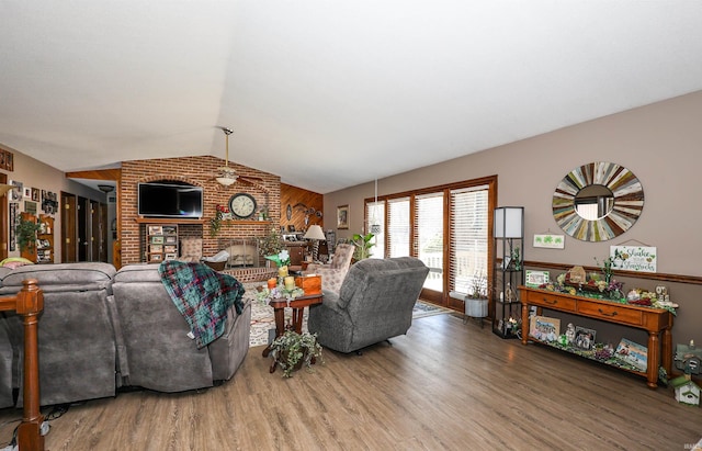 living room featuring a fireplace, lofted ceiling, and wood finished floors