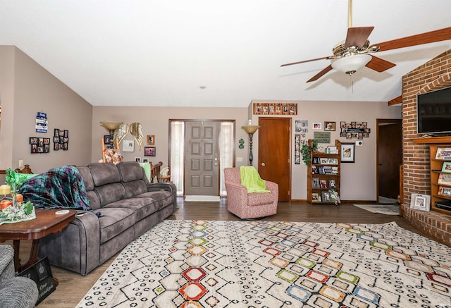 living area featuring baseboards, wood finished floors, a ceiling fan, and vaulted ceiling