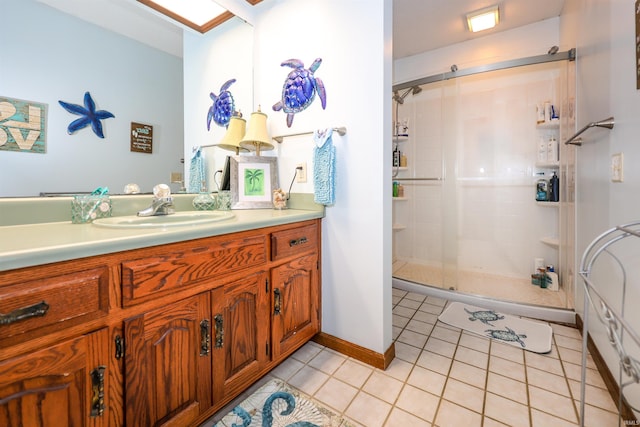 full bath featuring tile patterned flooring, a stall shower, vanity, and baseboards