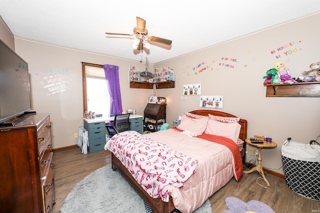 bedroom featuring ceiling fan, baseboards, and wood finished floors