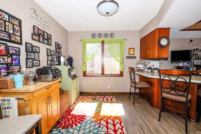 kitchen featuring a breakfast bar area, baseboards, and light wood-style flooring