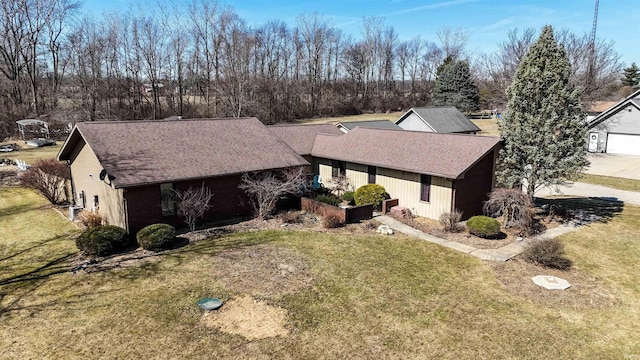 view of front of property featuring roof with shingles and a front yard