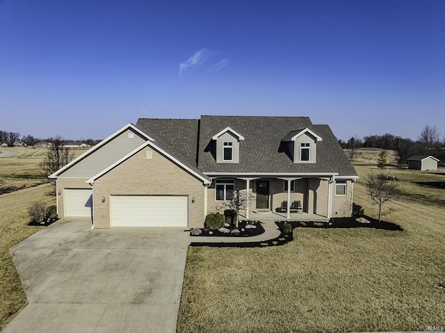 cape cod home with a porch, concrete driveway, a front yard, roof with shingles, and a garage