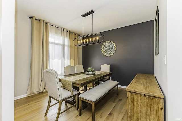 dining space with an inviting chandelier, light wood-style floors, and baseboards