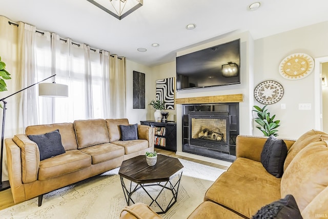 living area featuring a fireplace with flush hearth and wood finished floors