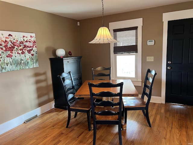 dining area with visible vents, baseboards, and wood finished floors