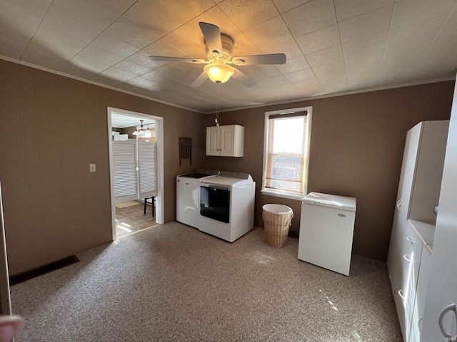 washroom with washing machine and dryer, light colored carpet, ornamental molding, cabinet space, and a ceiling fan