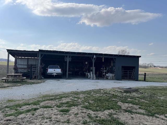 view of pole building with a carport and gravel driveway