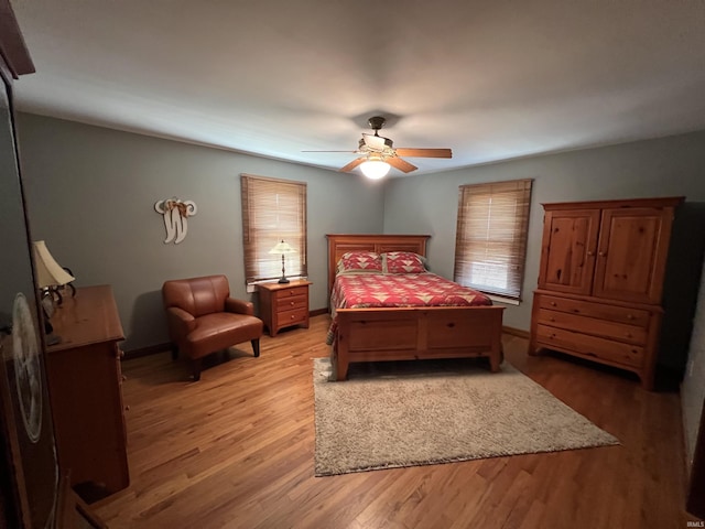 bedroom with baseboards, light wood-type flooring, and ceiling fan