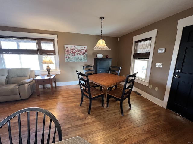 dining area featuring baseboards, a healthy amount of sunlight, and wood finished floors