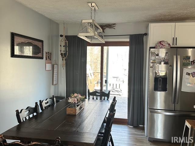 dining space featuring wood finished floors and a textured ceiling