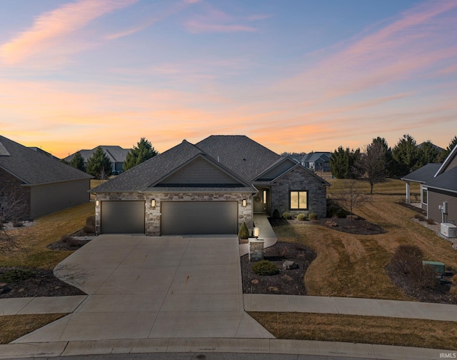 view of front of home with a garage, stone siding, driveway, and a shingled roof